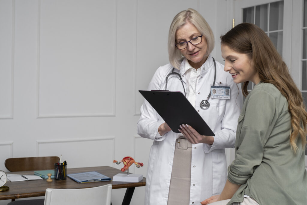 Ginecologista experiente mostra os resultados de exames para uma paciente sorridente durante uma consulta de rotina, destacando a importância da prevenção na saúde feminina.